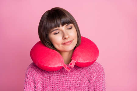 Photo of charming calm sleepy woman good mood wear neck pillow smile isolated on pink color backgroundの写真素材