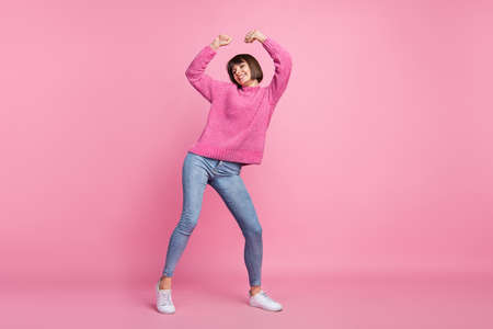 Full length photo of cheerful young happy positive woman dance good mood isolated on pastel pink color backgroundの写真素材