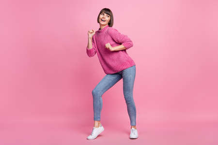 Full size photo of positive cheerful dreamy young woman dance look empty space isolated on pink color backgroundの写真素材