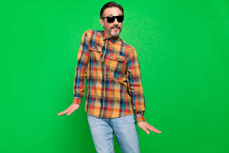 Portrait of attractive cheerful man fooling dancing having fun moving rest isolated over bright green color backgroundの写真素材