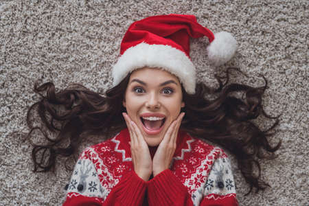 Top above high angle view photo of happy amazed young woman hold hands face xmas holiday sale indoors inside house homeの写真素材