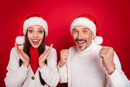 Portrait of attractive cheerful couple rejoicing eve festal time having fun isolated over bright red color backgroundの写真素材