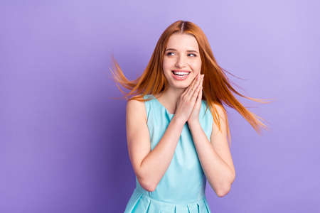 Photo of charming thankful positive nice lady look empty space fly wind hair isolated on violet color backgroundの写真素材