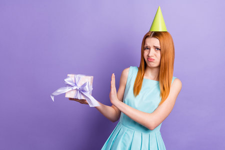 Photo of unhappy upset young woman dislike disgust present bad mood party isolated on purple color backgroundの写真素材