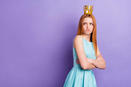 Photo of unhappy young upset woman look empty space crossed hands princess isolated on purple color backgroundの写真素材