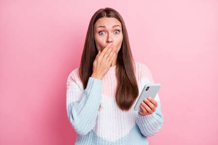 Photo of amazed shocked young woman mistake send message hold phone isolated on pink color...