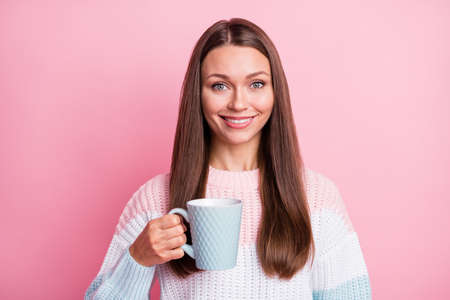 Photo portrait of happy girl drinking coffee on work break smiling isolated on pastel pink color backgroundの写真素材
