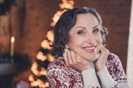 Photo portrait senior woman smiling wearing sweater with ornament celebrating xmasの写真素材