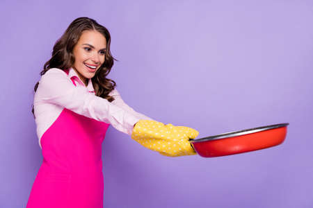 Photo of pretty positive person look interested hands hold pan toothy smile isolated on purple color backgroundの写真素材