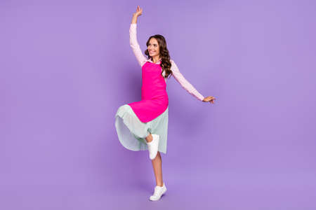Full length body size view of attractive cheerful housemaid dancing having fun good mood isolated over violet purple color backgroundの写真素材
