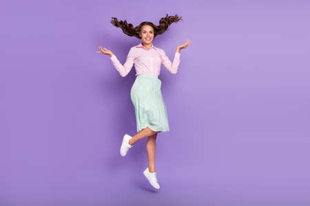 Full body photo of impressed young brunette lady jump wear shirt skirt shoes isolated on purple backgroundの写真素材