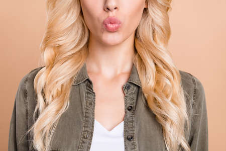 Cropped photo of charming young woman send air kiss blonde wavy hair enjoy isolated on beige color...