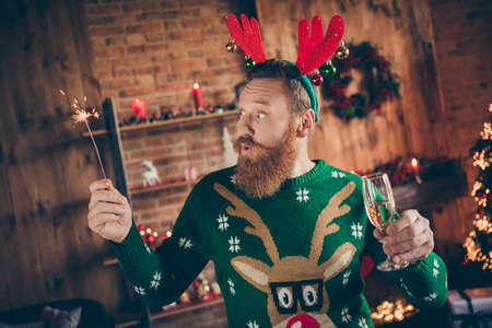 Portrait of attractive amazed funky guy drinking champagne holding bengal fire midnight at modern loft industrial style indoorsの写真素材