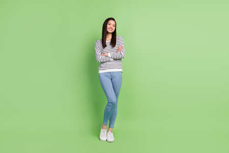 Full length body size view of attractive cheerful slim thin girl posing folded arms isolated over...