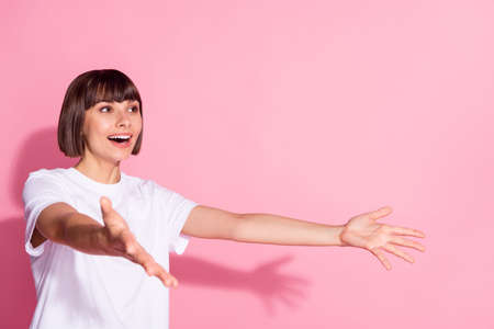 Profile side view portrait of attractive cheerful girl looking catching copy space isolated over pink pastel color backgroundの写真素材
