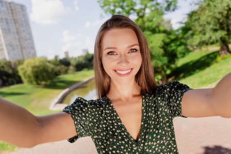 Photo of nice brown haired happy cheerful woman smile good mood make camera selfie outdoors outside...