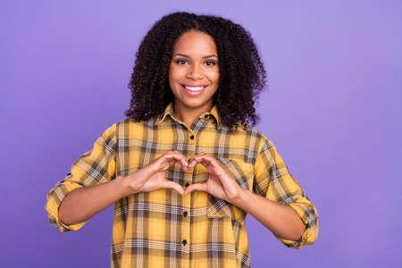 Photo of cheerful happy afro american young lady show fingers heart shape isolated on violet color backgroundの写真素材