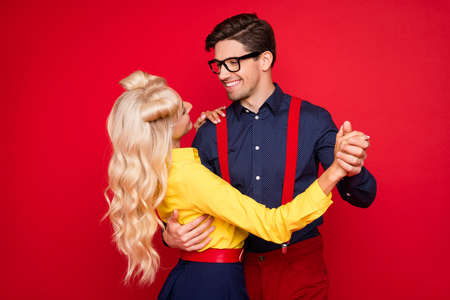 Photo of charming pretty young lady guy dressed pinup outfits smiling dancing boogie isolated red color backgroundの写真素材