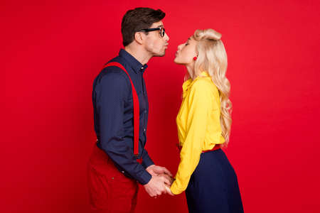 Photo of attractive flirty young guy lady wear pin up clothes dancing jive kissing isolated red color backgroundの写真素材