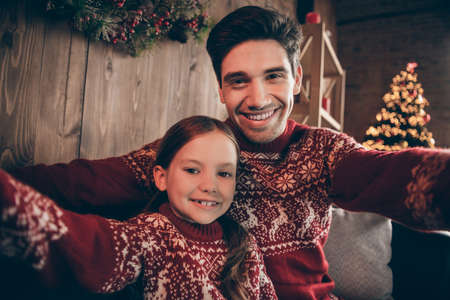 Photo of two positive people relatives take blog portrait record noel eve wear sweater in decorated x-mas home indoorsの写真素材