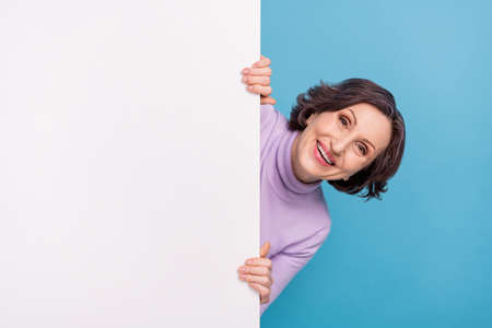 Photo of excited elderly woman happy positive smile hold paper banner ads isolated over blue color...