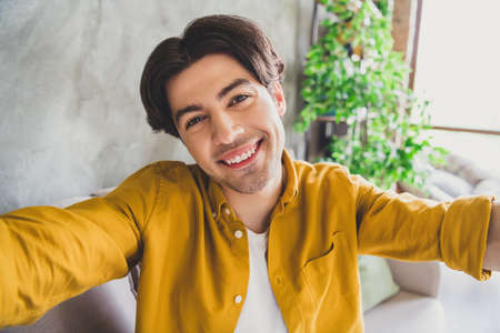 Photo of nice positive friendly guy shoot selfie beaming white smile look camera wear yellow shirt...