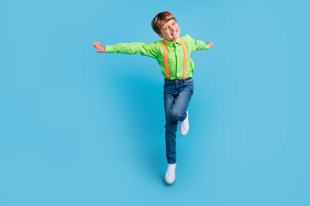 Full length body size view of attractive cheerful carefree boy jumping good mood isolated over teal turquoise color backgroundの写真素材