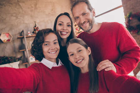 Photo of blogger influencer family embrace shoot selfie portrait toothy smile in decorated x-mas home indoorsの写真素材