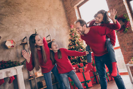 Photo of positive friendly people father carry son piggyback wave hand together in decorated x-mas home indoorsの写真素材
