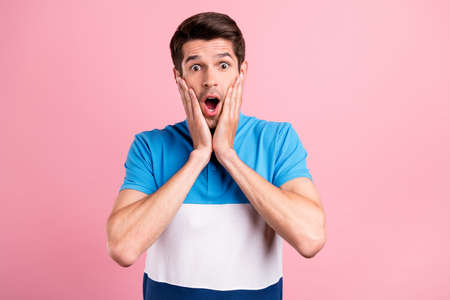 Photo of young shocked frightened crazy guy touch cheeks have problem bad news isolated on pink color backgroundの写真素材