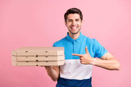 Photo of lovely brunet millennial guy point pizza wear striped t-shirt isolated on pink color backgroundの写真素材