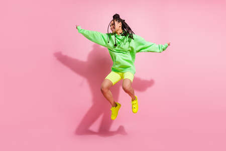 Full body photo of happy afro american woman good mood look empty space isolated on pink color backgroundの写真素材