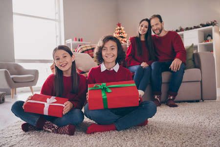 Photo of sweet pretty son daughter dad mom wear red pullovers smiling hugging holding christmas...