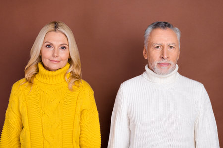 Photo of nice blond aged lady grey hairdo beard man wear yellow white pullovers isolated on brown...