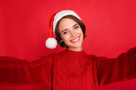 Photo of young girl happy positive smile shoot selfie eve time spirit isolated over red color backgroundの写真素材