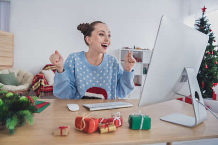 Portrait of attractive cheerful girl using pc having fun calling friend watching video staying alone at home indoorsの写真素材