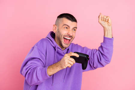 Photo of hooray millennial brunet guy wear violet hoodie isolated on pink backgroundの写真素材