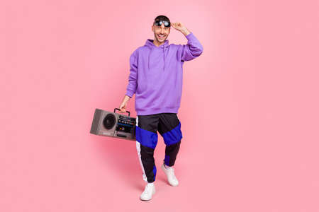 Full body photo of young cool guy ego party hold boombox music lover isolated over pink color backgroundの写真素材