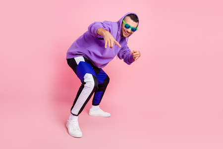 Full length photo of funky young brunet guy dance wear eyewear hoodie pants shoes isolated on pink backgroundの写真素材