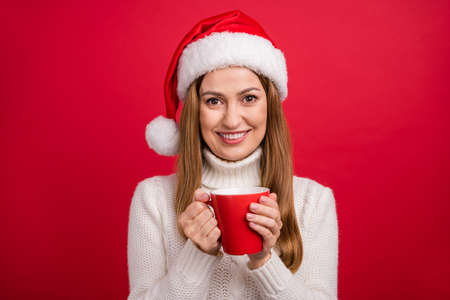 Portrait of attractive cheery woman drinking beverage hot milk festal day rest isolated over bright red color backgroundの写真素材