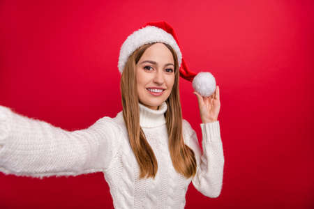 Self-portrait of attractive cheerful woman spending day festal good mood isolated over bright red color backgroundの写真素材