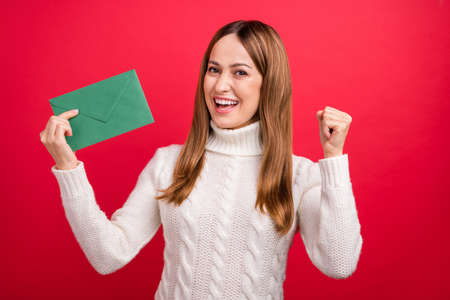 Portrait of attractive cheerful woman holding letter list receive having fun isolated over bright red color backgroundの写真素材