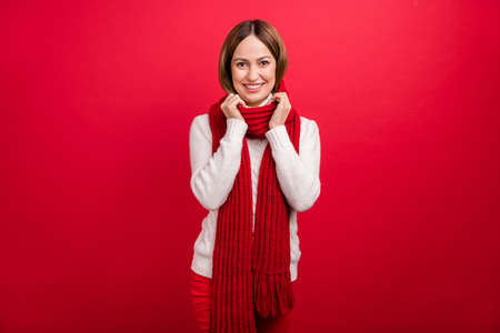 Portrait of attractive cheerful woman wearing warm cosy accessory garment isolated over shine red color backgroundの写真素材