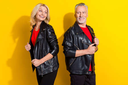 Profile side view portrait of two nice cheerful cool grey-haired spouses having fun isolated over bright yellow color backgroundの写真素材