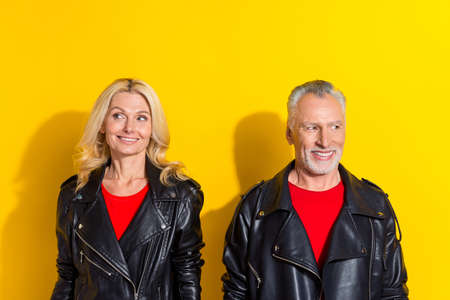 Portrait of two attractive cheerful cool grey-haired spouses thinking copy space isolated over vivid yellow color backgroundの写真素材