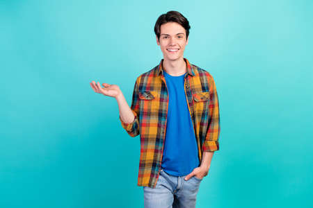 Photo of nice guy palm demonstrate empty space object sale wear plaid shirt isolated aquamarine color backgroundの写真素材