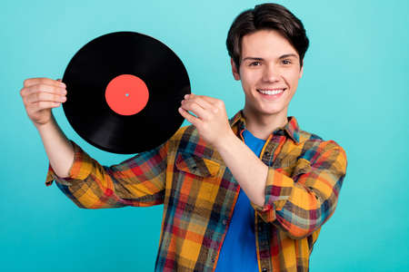 Photo of reliable dj guy demonstrate vinyl disk wear checkered shirt isolated aquamarine color backgroundの写真素材