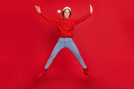 Full length photo of young girl happy positive smile jump up holiday winter isolated over red color...
