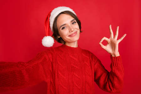 Photo of young girl happy positive smile shoot selfie show okay alright choice feedback isolated over red color backgroundの写真素材