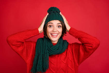 Photo portrait young woman wearing knitted headwear scarf smiling happy isolated vibrant red color backgroundの写真素材